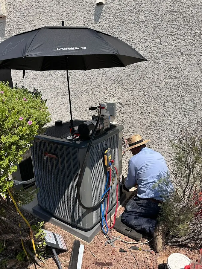 HVAC technician performing outdoor AC maintenance in Vineyard