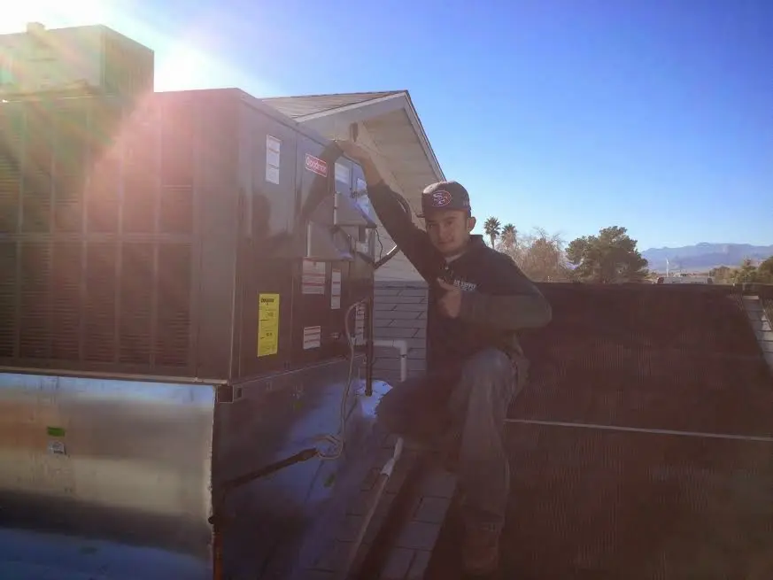 HVAC technician performing AC Tune-Up on a rooftop unit in Vineyard